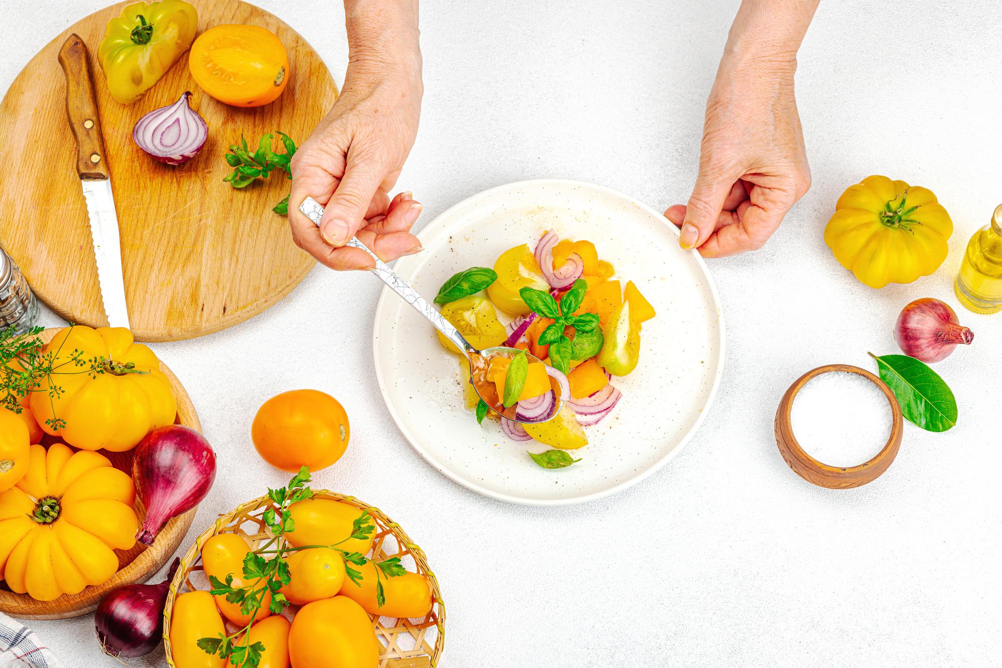 Chef arranging colorful plated dishes on wooden table